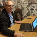 Uomo sorridente con laptop presso Interlingua Formazione